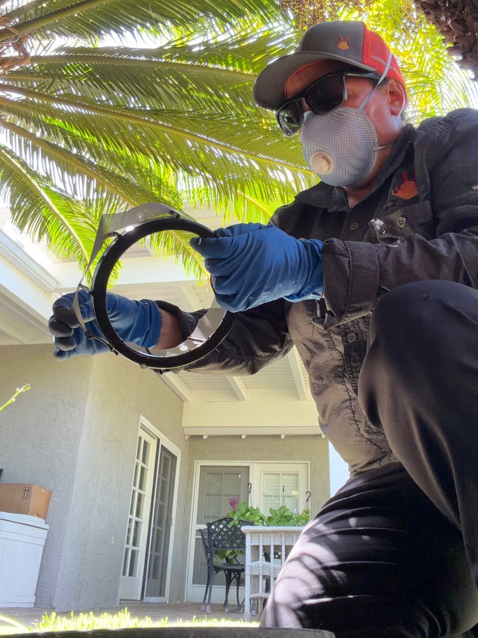 Chris lifting the floater out of a backyard mosquito station during a monthly visit in La Puente